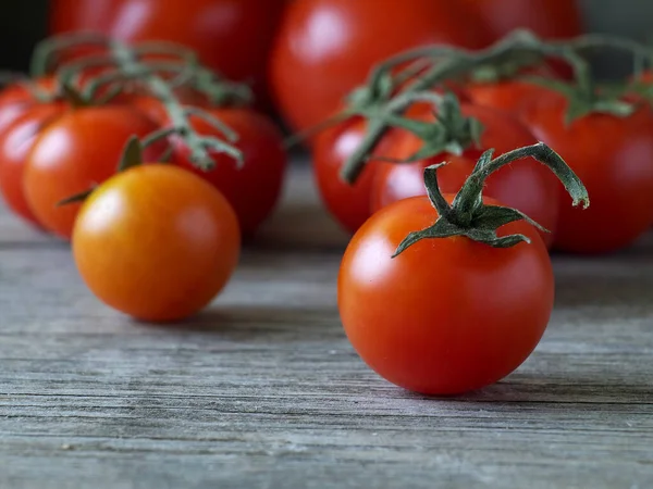 Tomate Maduro Cereja Frente Outros Tomates Mesa Madeira Profundidade Rasa — Fotografia de Stock