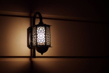 Sarı duvarda Retro tarzı siyah lamba. Karanlıkta lamba aydınlatan duvar