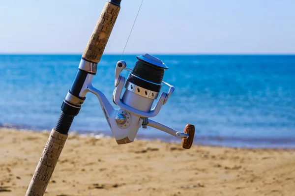 ビーチで回転リールで釣竿 海の海岸で塩水釣り スペースのコピー ストック画像