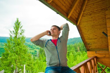 genç adam cep telefonu ile arama. Dağlar. İletişim co