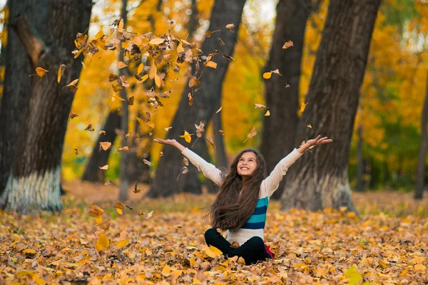 Adolescente chica drop up hojas en otoño parque —  Fotos de Stock