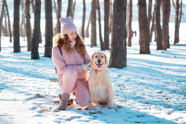 Young female woman playing golden retriever dog in snow — Stock Photo, Image