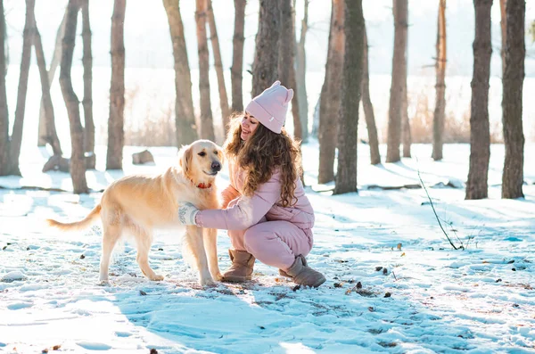 在雪地里玩金毛猎犬的小女孩 — 图库照片