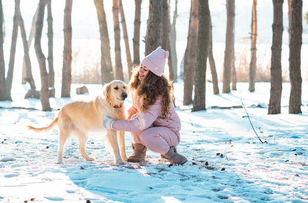 Young girl playing golden retriever dog in snow Stock Image