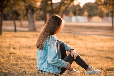 Genç bayan bahar günbatımı parkında poz veriyor