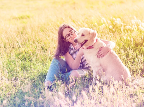 Genç bir kadın bahar parkında köpeğine sarılıyor. — Stok fotoğraf