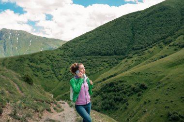 Kız dağın tepesinde mükemmel manzaralı bir bağlantı arıyor..