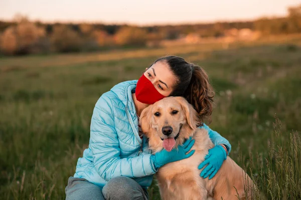 Ung lockig kvinna med sin hund Golden retriever omfamna utomhus — Stockfoto