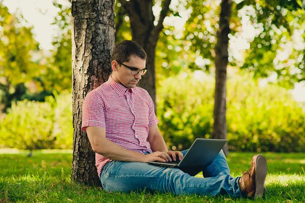 jonge man aan het werk in het park met laptopcomputer