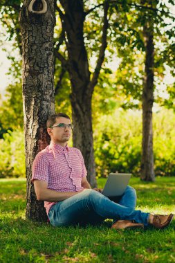 jonge man aan het werk in het park met laptopcomputer