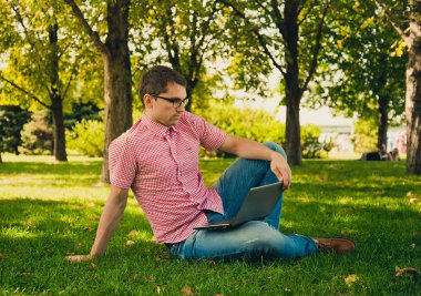 jonge man aan het werk in het park met laptopcomputer