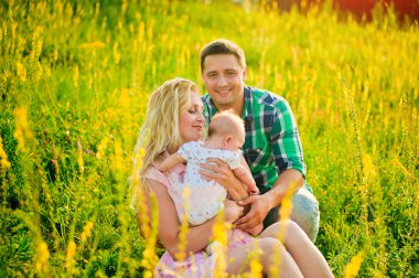 Mutlu bir genç aile yaz günü dışarıda vakit geçirir.