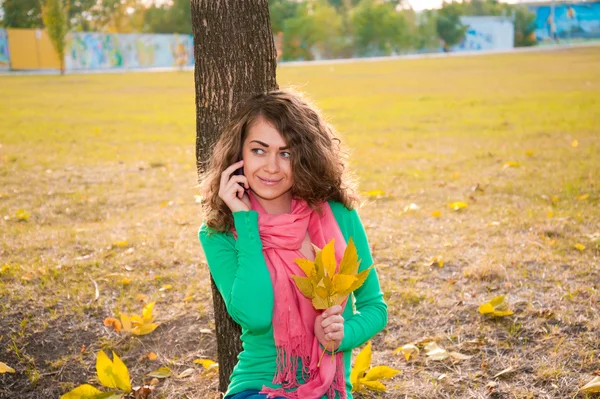 Young curly woman  in autumn park — Stock Photo, Image