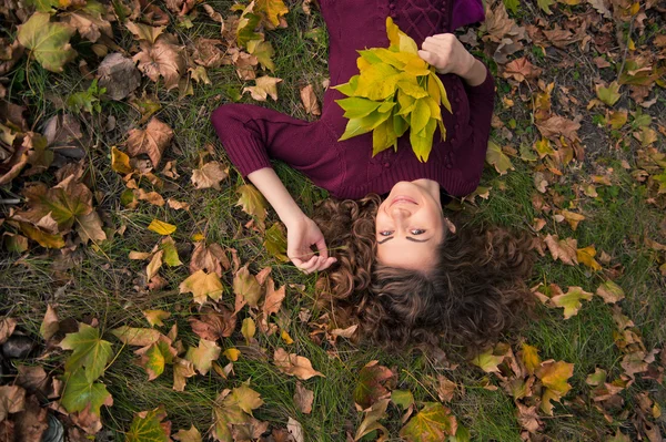 Jeune fille avec des feuilles en automne — Photo