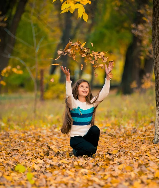 Adolescente chica drop up hojas en otoño parque —  Fotos de Stock