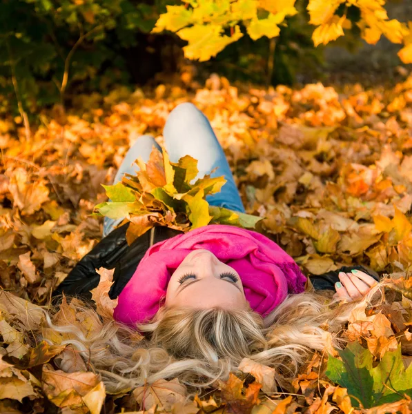 Imagen de una joven acostada en hojas de otoño —  Fotos de Stock