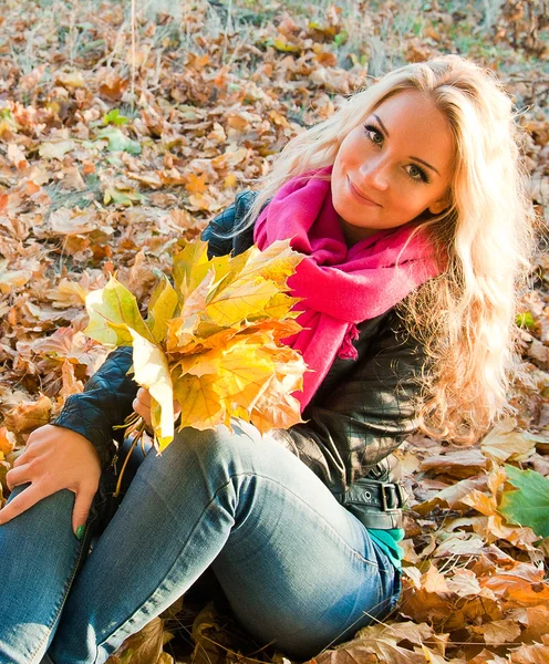 Menina bonita segurando folhas no outono — Fotografia de Stock