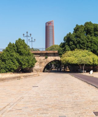 Geniş yaya alanı ve bisiklet yolu (Sevilla, İspanya) ile Triana köprüsünden geçmek için geçiş. Arka planda Torre Sevilla ya da Torre Pelli olarak bilinen şehrin en uzun gökdeleni duruyor..