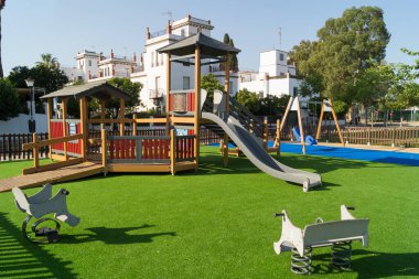 Eğlence alanı ve yeşil halı ve slaytlarla dolu çocuk parkı.
