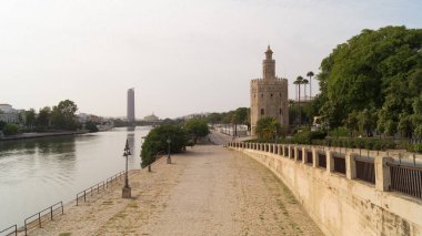 Guadalquivir nehri, Torre del Oro, Triana köprüsü ve Torre Sevilla gökdelenleri bulutlu bir günde Seville 'de (Endülüs, İspanya).