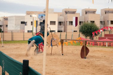 Gines, İspanya; 14 Aralık 2025: Silahlı ortaçağ şövalyesi, seyircilerle birlikte bir başka şövalye ile karşılaşmak için atına biniyor..