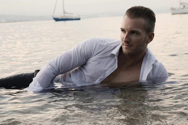 Hombre guapo acostado en el agua —  Fotos de Stock
