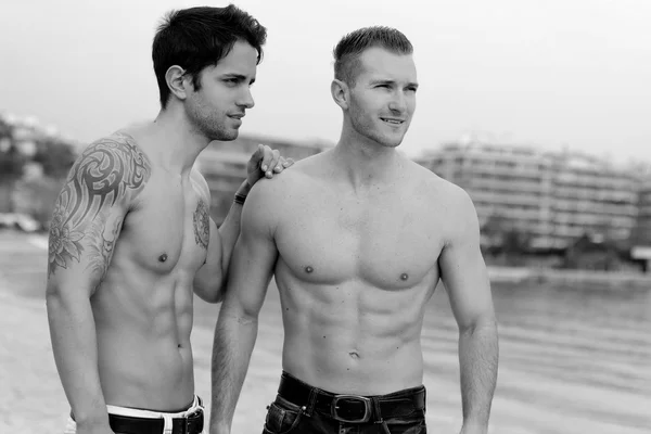 Två sexiga män poserar på stranden — Stockfoto