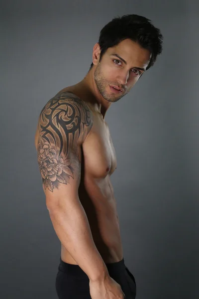 Сексуальный татуированный мужчина позирует — стоковое фото