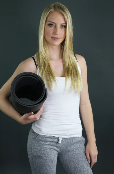 Sporty girl holding an exercise mat — Stock Photo, Image