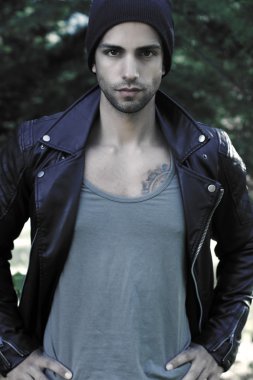 Bir deri ceket ve bir şapka giyen çekici adam