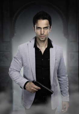 Genç adam silah taşıyor. 