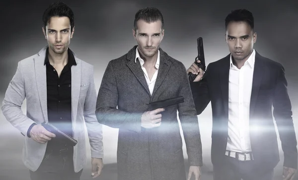 Tres hombres de moda sosteniendo arma —  Fotos de Stock