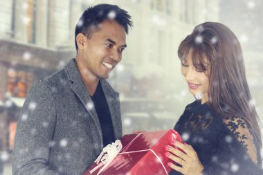 Genç çift bir hediye paketi sunan 