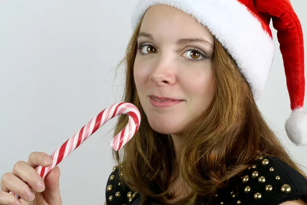 Mujer joven con un sombrero de Navidad y bastón de caramelo — Foto de Stock