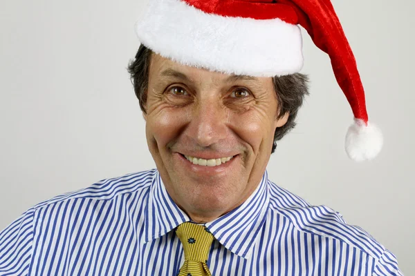 Empresario sonriendo con un sombrero de santa — Foto de Stock