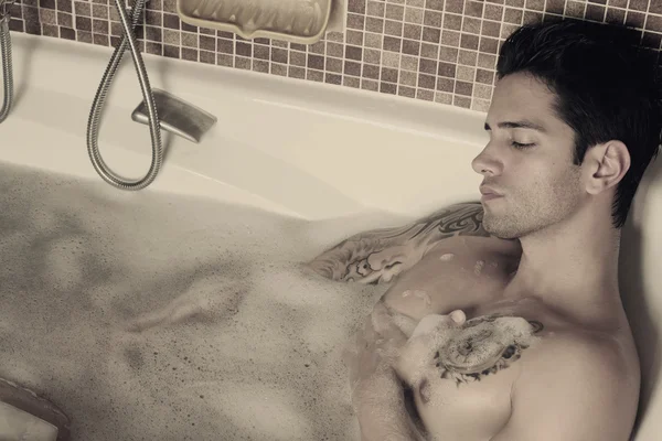Сексуальный мужчина лежит в ванной — стоковое фото