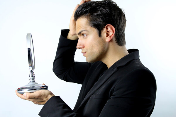 Handsome man who admires her face in a mirror