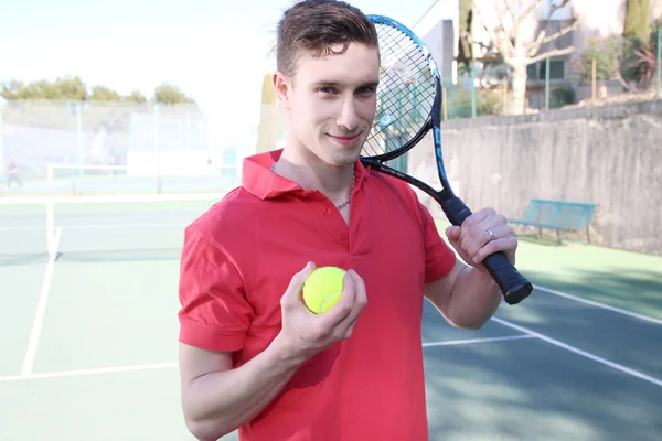 Молодой человек держит теннисную ракетку — стоковое фото