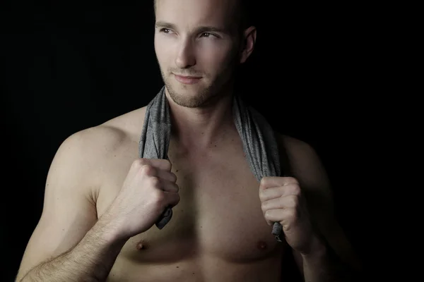 Handsome muscular man holding a towel — Stock Photo, Image