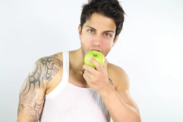 Uomo muscolare mangiare una mela — Foto Stock