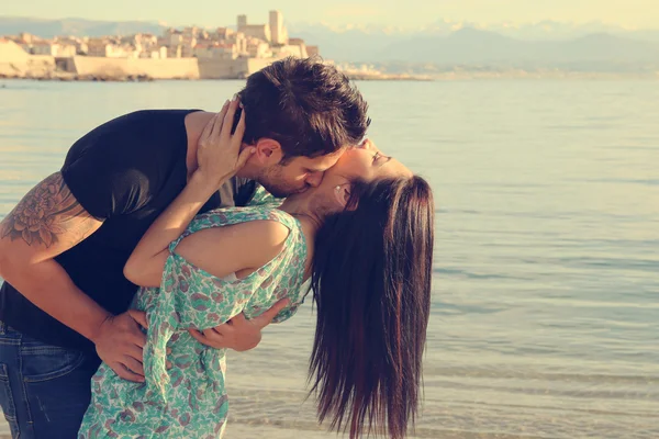 Молодая пара целуется на пляже Стоковое Фото