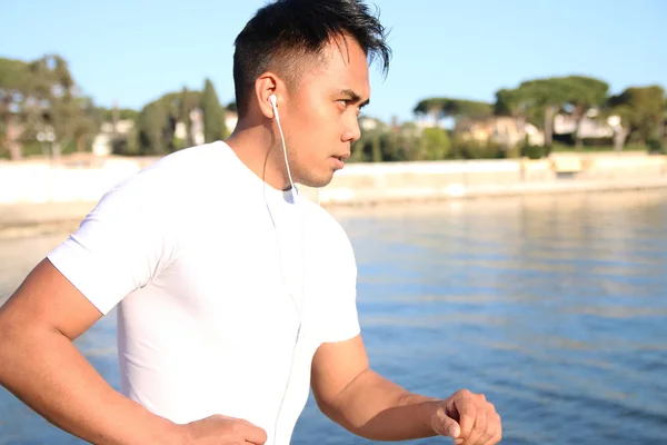 Man running in front of the beach — Stock Photo, Image