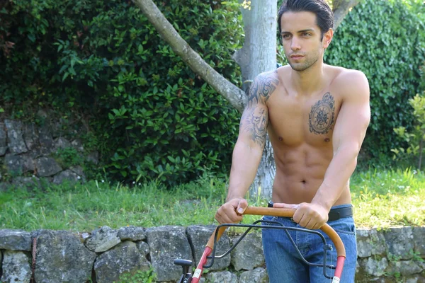 Sexy gardener using a lawn mower — Stock Photo, Image