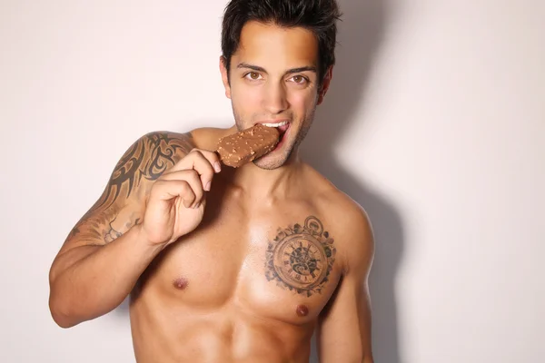 Sexy male eating ice cream — Stock Photo, Image