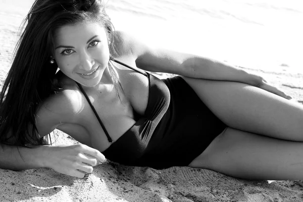 Brunette lying in the sand — Stock Photo, Image