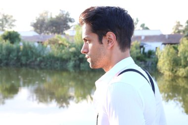 young man next to a pond