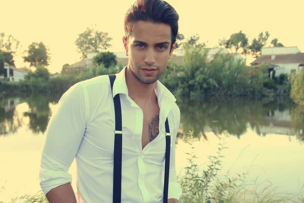 Young man next to a pond — Stock fotografie