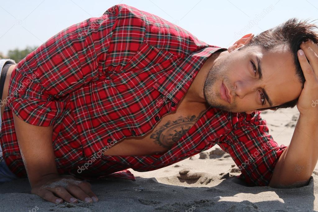 handsome male lying on the sand