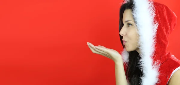 Hermosa chica vestida en santa claus sobre un fondo rojo — Foto de Stock