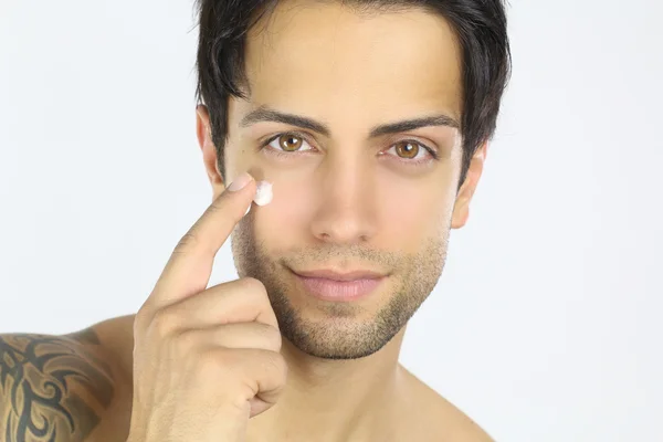 Joven aplicando crema — Foto de Stock